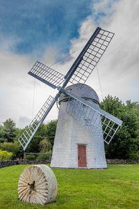 Traditional windmill on field against sky