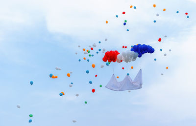 Low angle view of balloons against sky