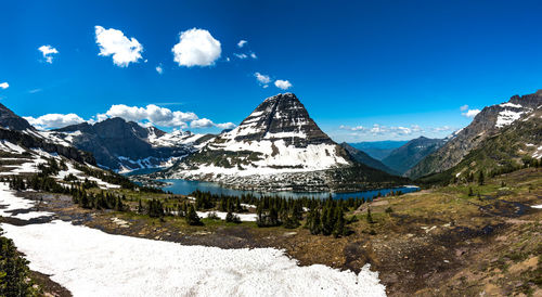 Scenic view of snowcapped mountains against blue sky