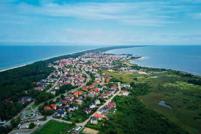 High angle view of townscape by sea against sky