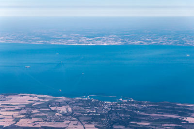 Aerial view of city by sea against sky