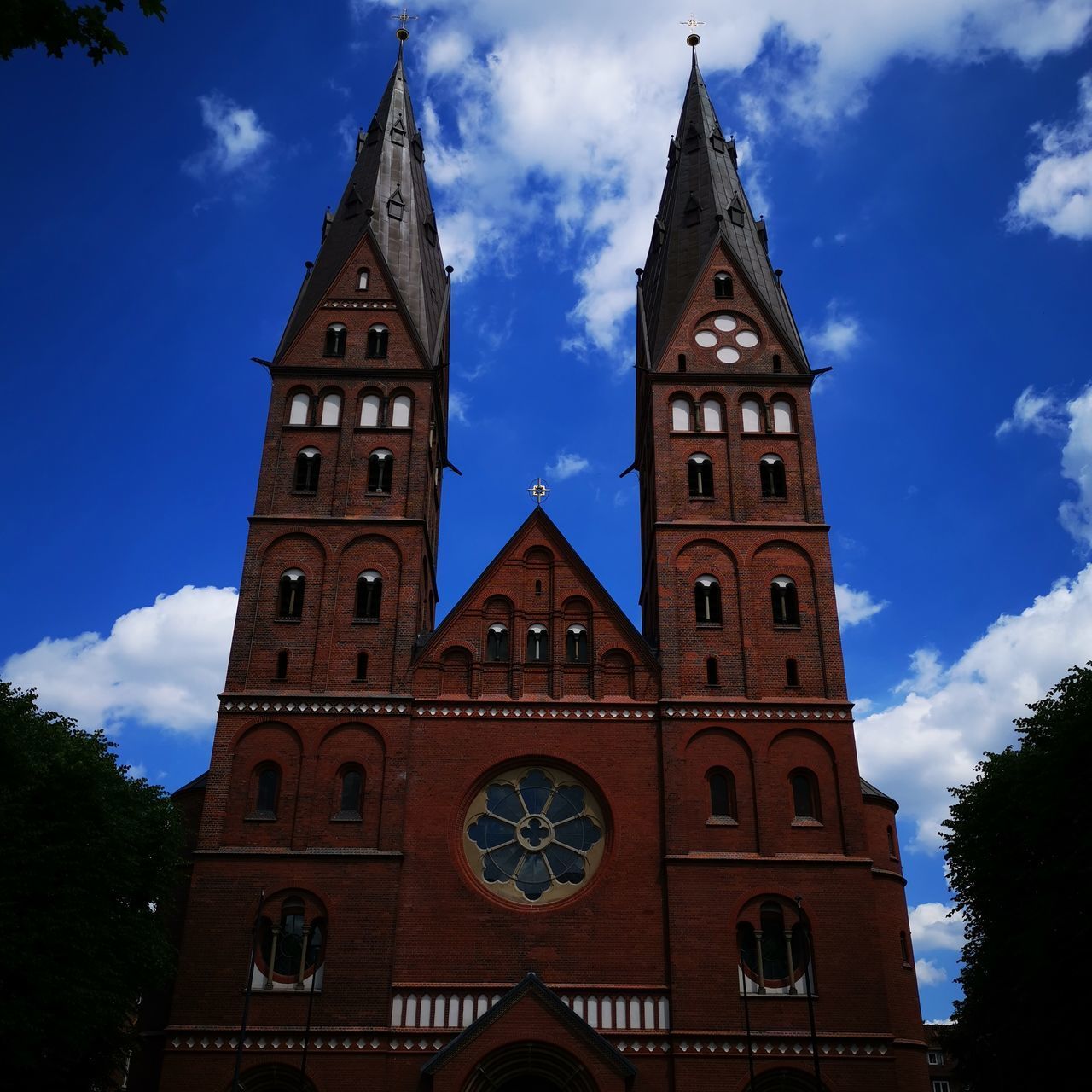 LOW ANGLE VIEW OF CLOCK TOWER BY BUILDING AGAINST SKY