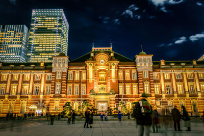 People at illuminated building entrance