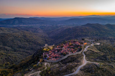 Drone aerial panorama of sortelha historic village at sunset with lights on the castle wind turbines