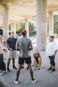 Rear view of male coach conducting sports training with team