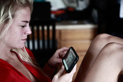 Close-up of young woman watching movie on mobile