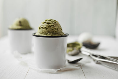 Close-up of ice cream in mugs on table