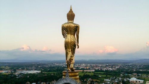 Large buddha statue against townscape