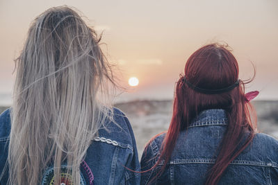 Rear view of woman against sky during sunset