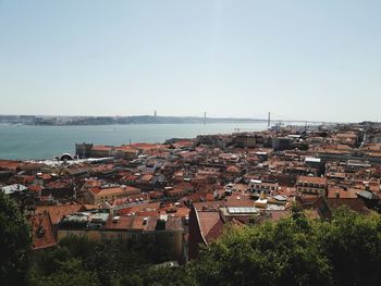 High angle view of townscape by sea against clear sky