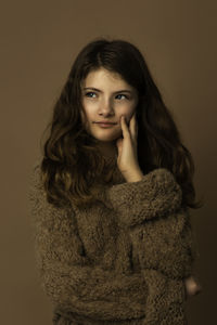 Portrait of young woman against black background