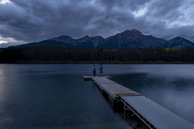 Scenic view of lake by mountains against sky