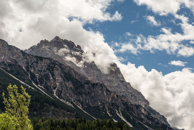 Low angle view of mountains against cloudy sky