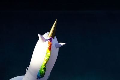 Close-up of multi colored umbrella against blue background