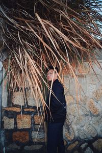 Portrait of young man standing by wall outdoors