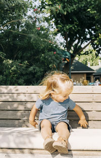 Full length of cute girl sitting outdoors