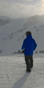 Rear view of woman standing on snow covered landscape