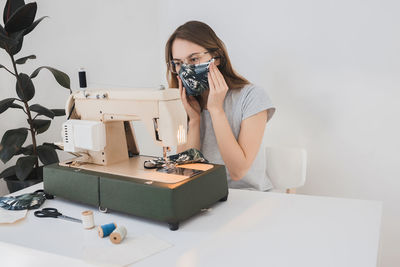 Woman photographing with camera on table