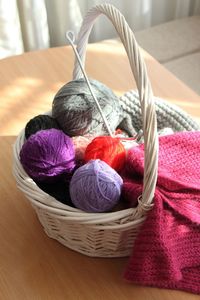 High angle view of multi colored wool balls in basket on table at home