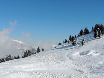 Scenic view of snowcapped mountains against clear blue sky