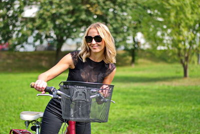 Young woman riding bicycle on grass