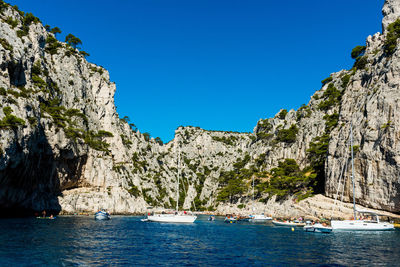 Scenic view of sea and mountains against clear blue sky