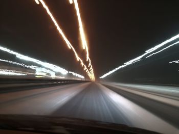 Light trails on road seen through car windshield at night