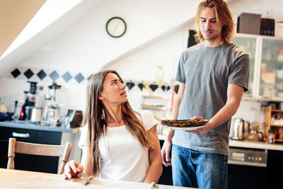 Happy young woman standing on table