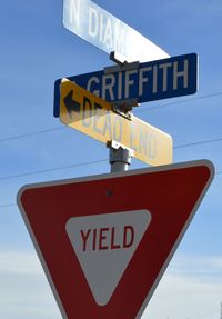 Low angle view of road sign against sky