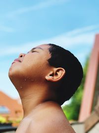 Close-up portrait of young woman with eyes closed against sky