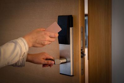 Cropped hands opening door with hotel key