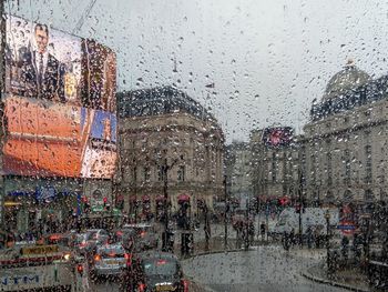 City seen through wet window during rainy season