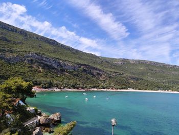 High angle view of sea and mountains against sky