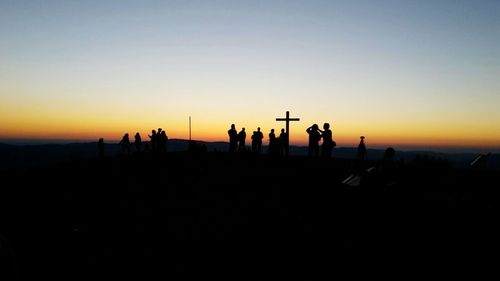 Silhouette people on beach against sky during sunset