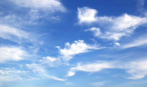 Low angle view of sunlight streaming through clouds