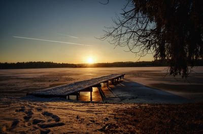 Scenic view of frozen lake against sky during sunset