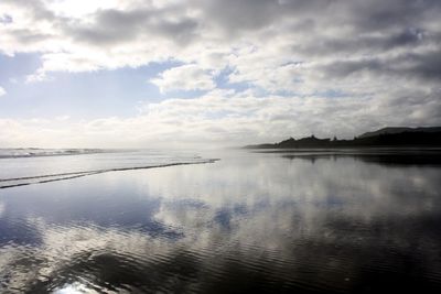Reflection of cloudy sky in river during sunny day