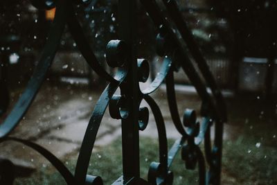 Close-up of water hanging from metal