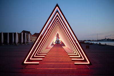 Illuminated bridge against clear sky in city