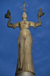 Low angle view of statue against blue sky