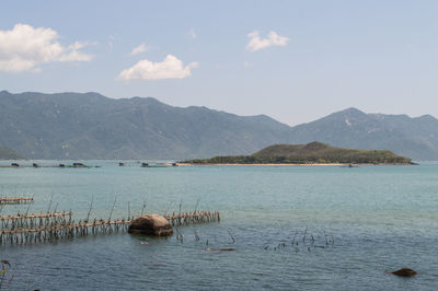 Scenic view of lake by mountains against sky