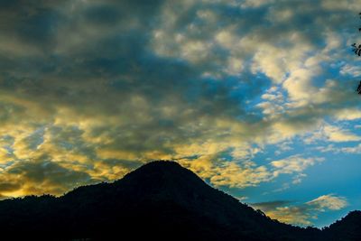 Low angle view of silhouette mountain against dramatic sky