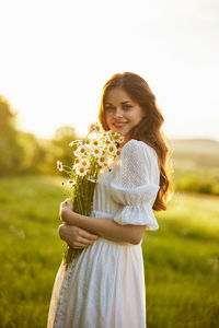 Portrait of smiling young woman holding flowers