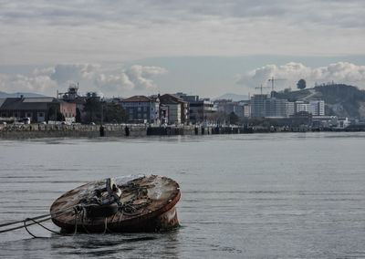 Boat in sea against buildings in city