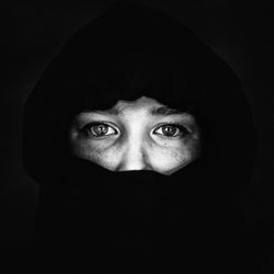 Portrait of woman against black background