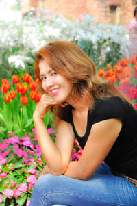 Portrait of beautiful woman sitting by plants