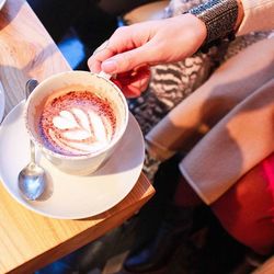 Cropped hand holding coffee cup