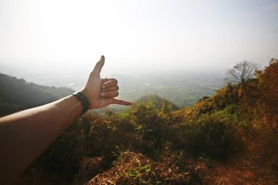 Midsection of person on mountain against sky