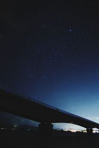 Low angle view of bridge against sky at night