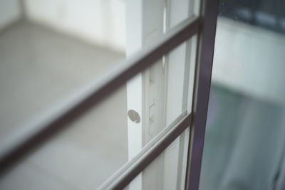 Close-up of metal railing against white wall